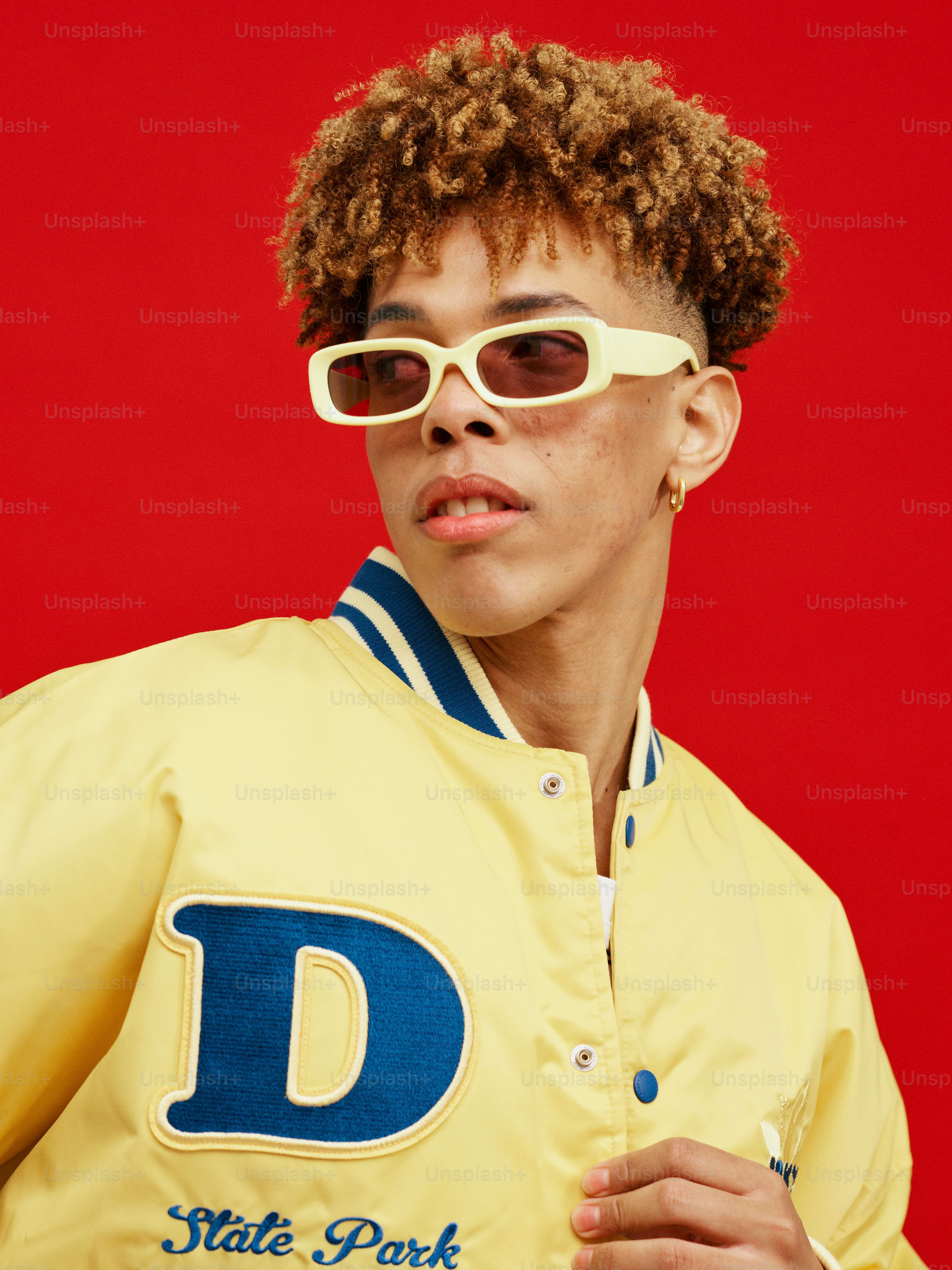 a woman wearing a yellow jacket and white sunglasses