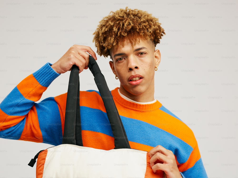 a young man holding a white and black bag
