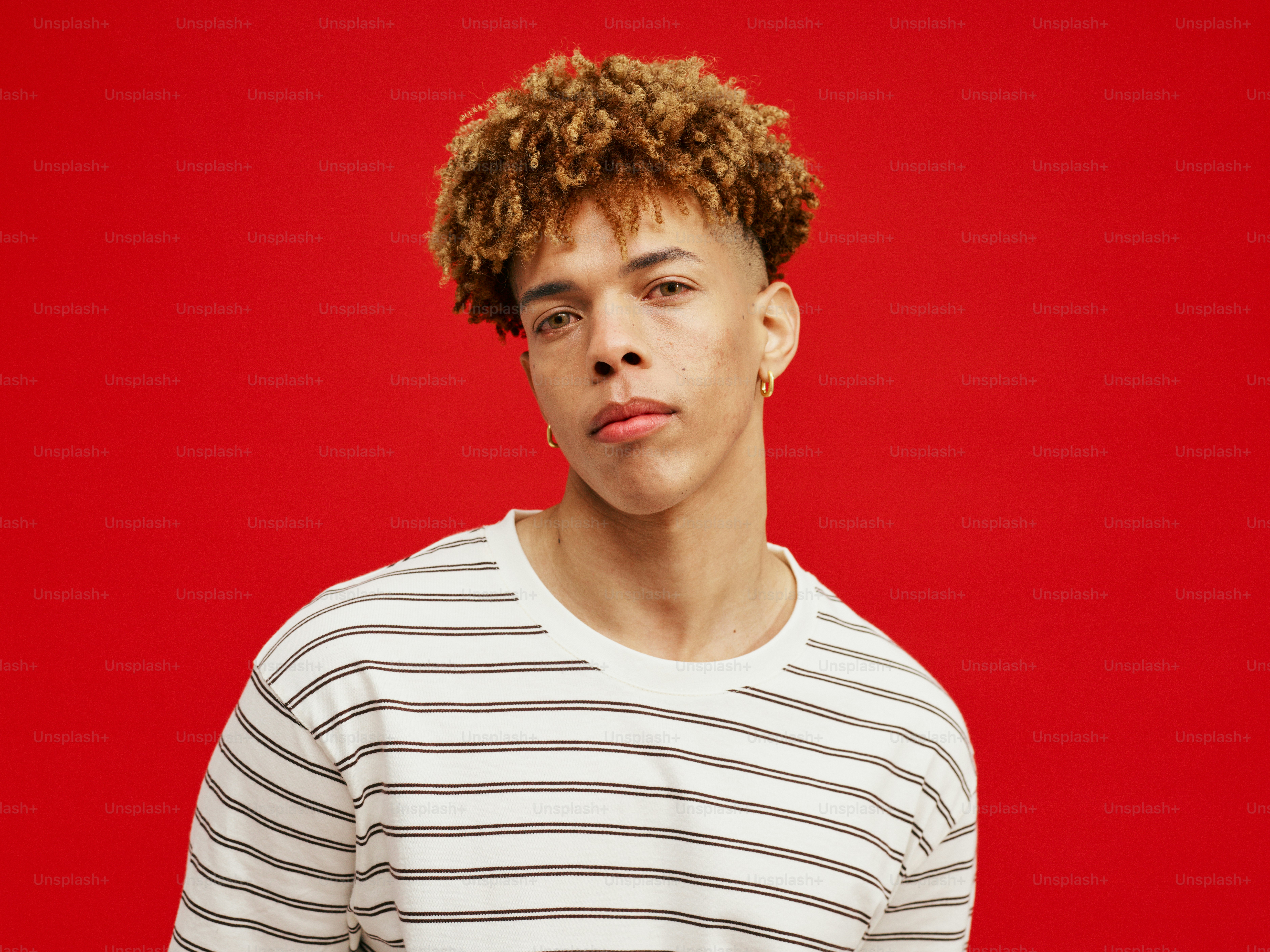 um homem com cabelos cacheados vestindo uma camisa listrada