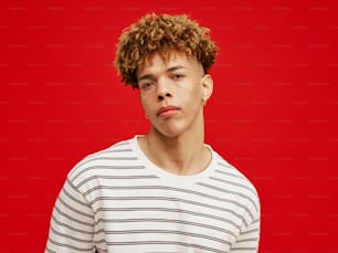 a man with curly hair wearing a striped shirt