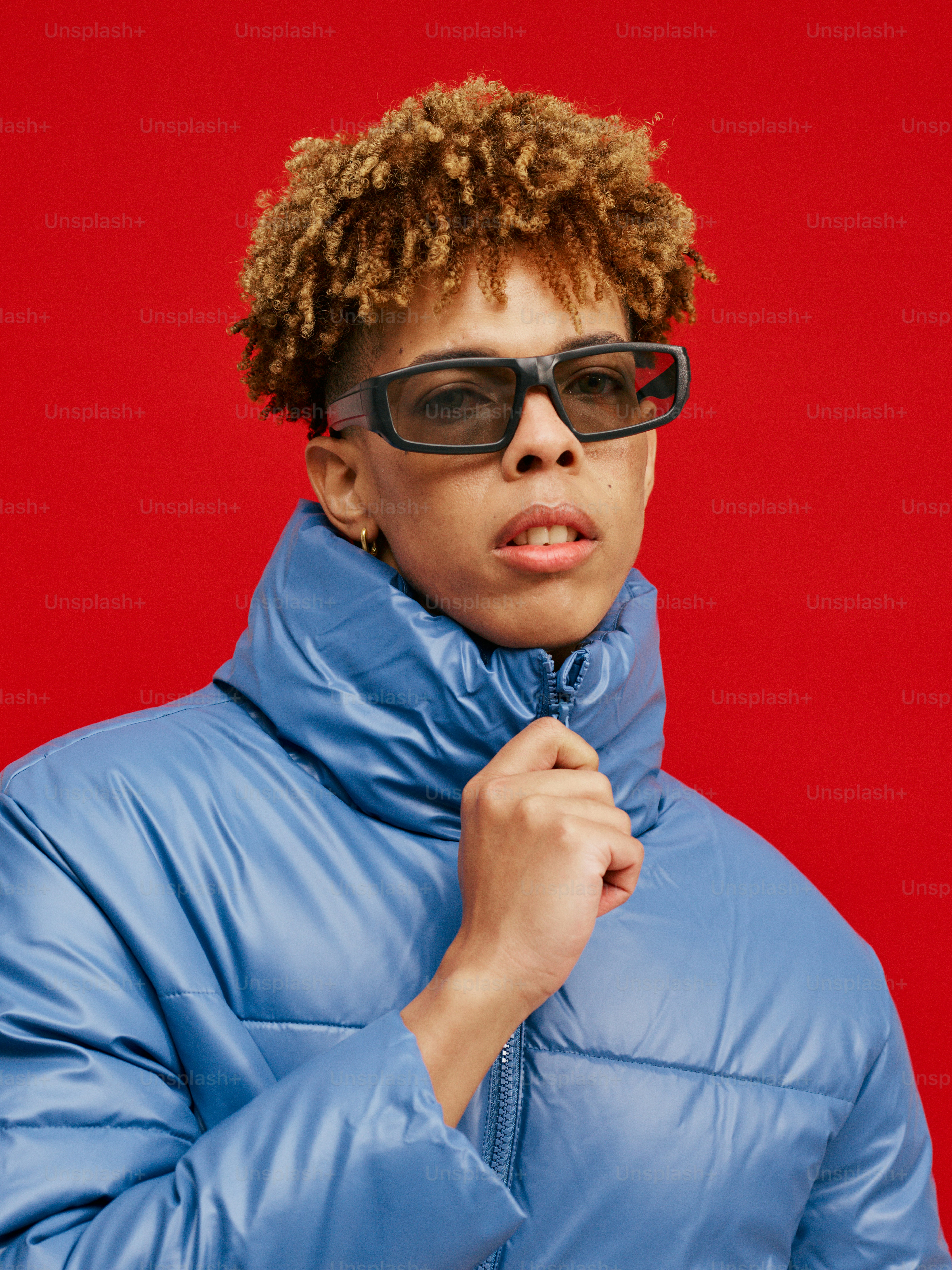 a person wearing a blue jacket and sunglasses