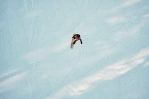 Un hombre montando una tabla de snowboard por la ladera de una ladera cubierta de nieve