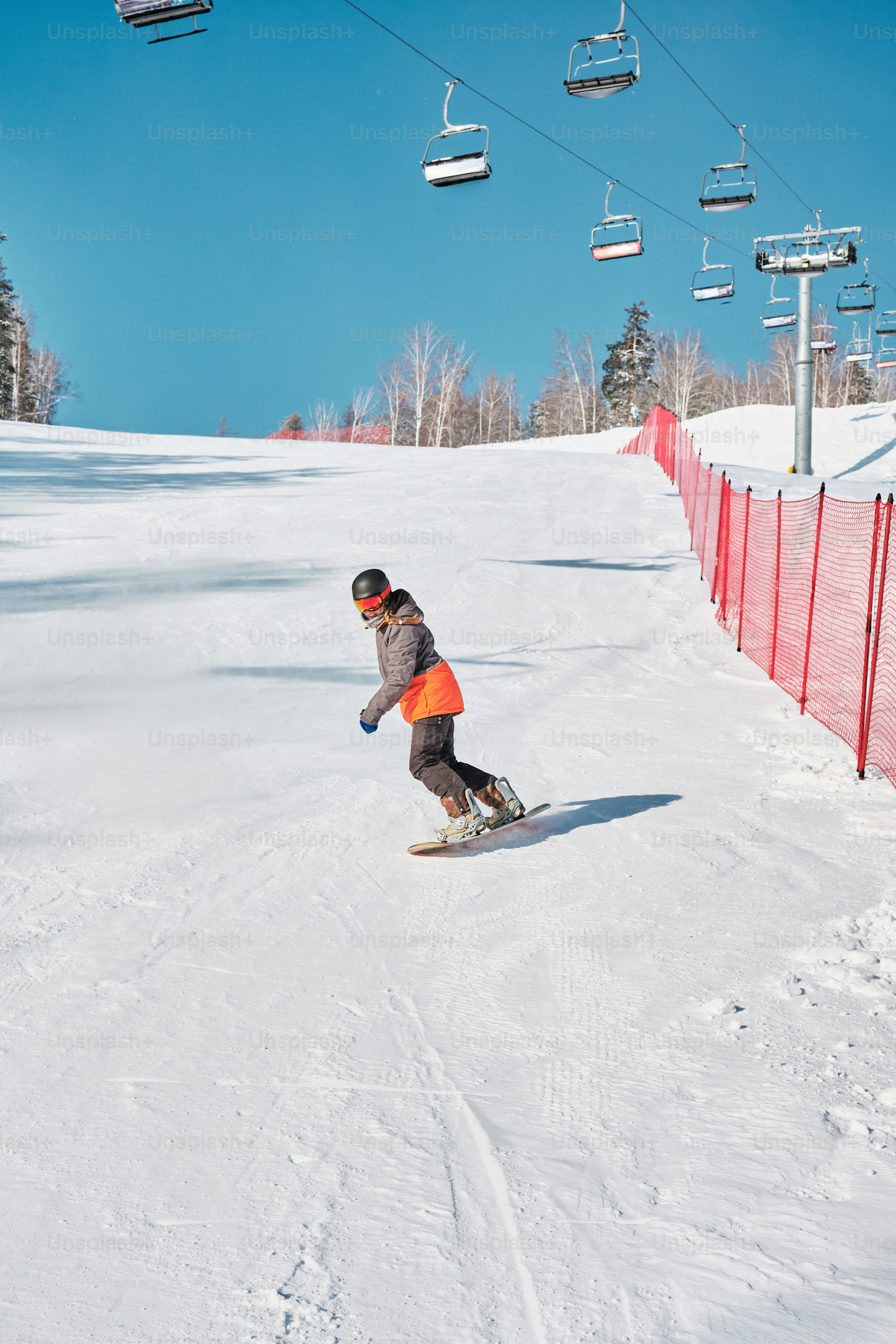 A person riding a snowboard down a snow covered slope photo – Snowboard ...