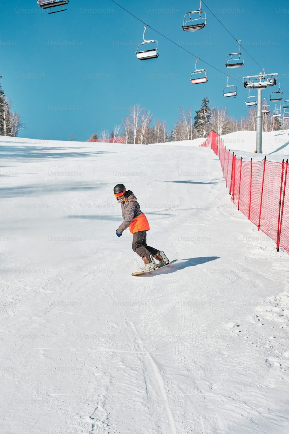 a man riding a snowboard down a snow covered slope