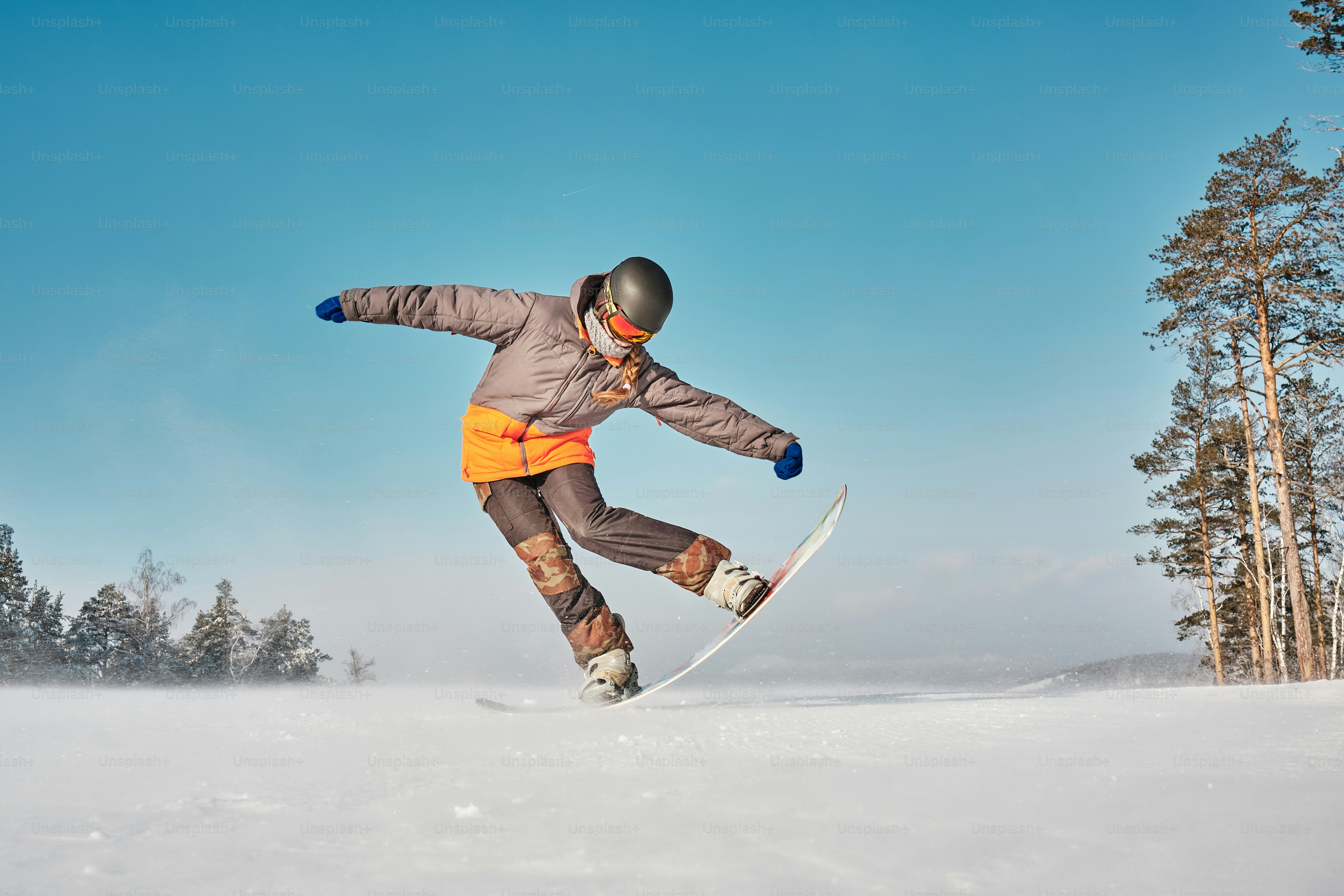 a man riding a snowboard down a snow covered slope