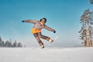 un homme faisant du snowboard sur une pente enneigée