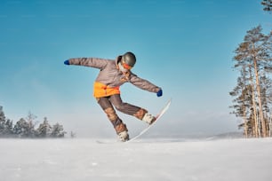 a man riding a snowboard down a snow covered slope