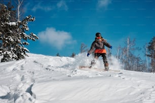 uma pessoa montando um snowboard por uma encosta coberta de neve