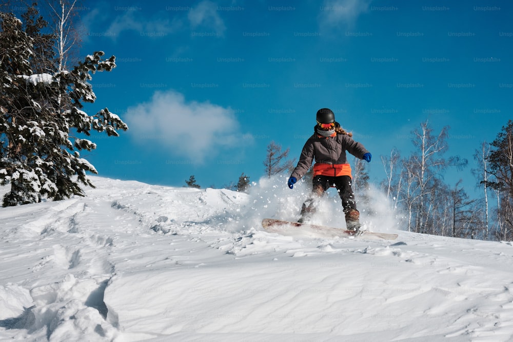 eine Person, die mit einem Snowboard einen schneebedeckten Hang hinunterfährt