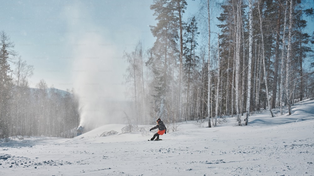 a man riding a snowboard down a snow covered slope