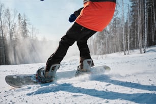 a person riding a snowboard down a snow covered slope