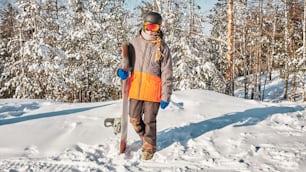 a snowboarder is standing in the snow with his board