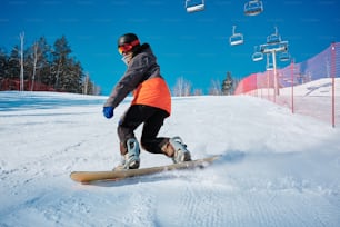 a man riding a snowboard down a snow covered slope