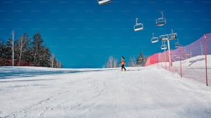 um homem montando um snowboard por uma encosta coberta de neve