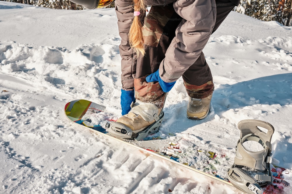 a person standing on a snowboard in the snow