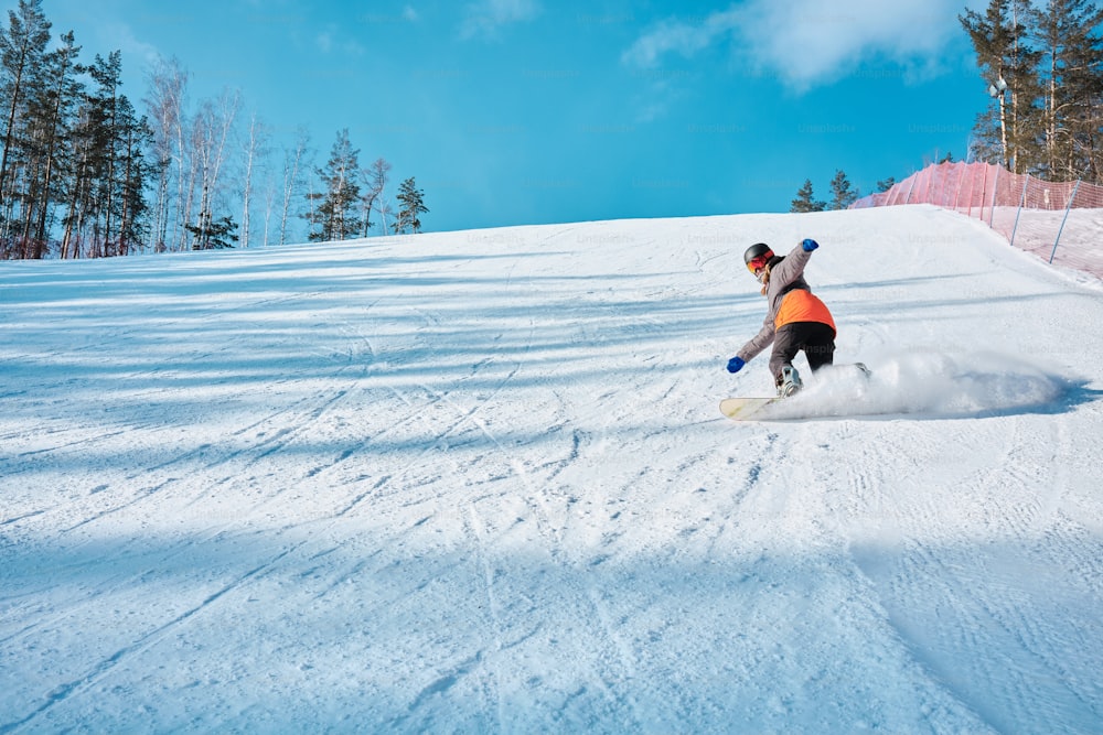 ein Mann, der mit einem Snowboard einen schneebedeckten Hang hinunterfährt