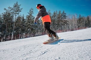 a man riding a snowboard down a snow covered slope