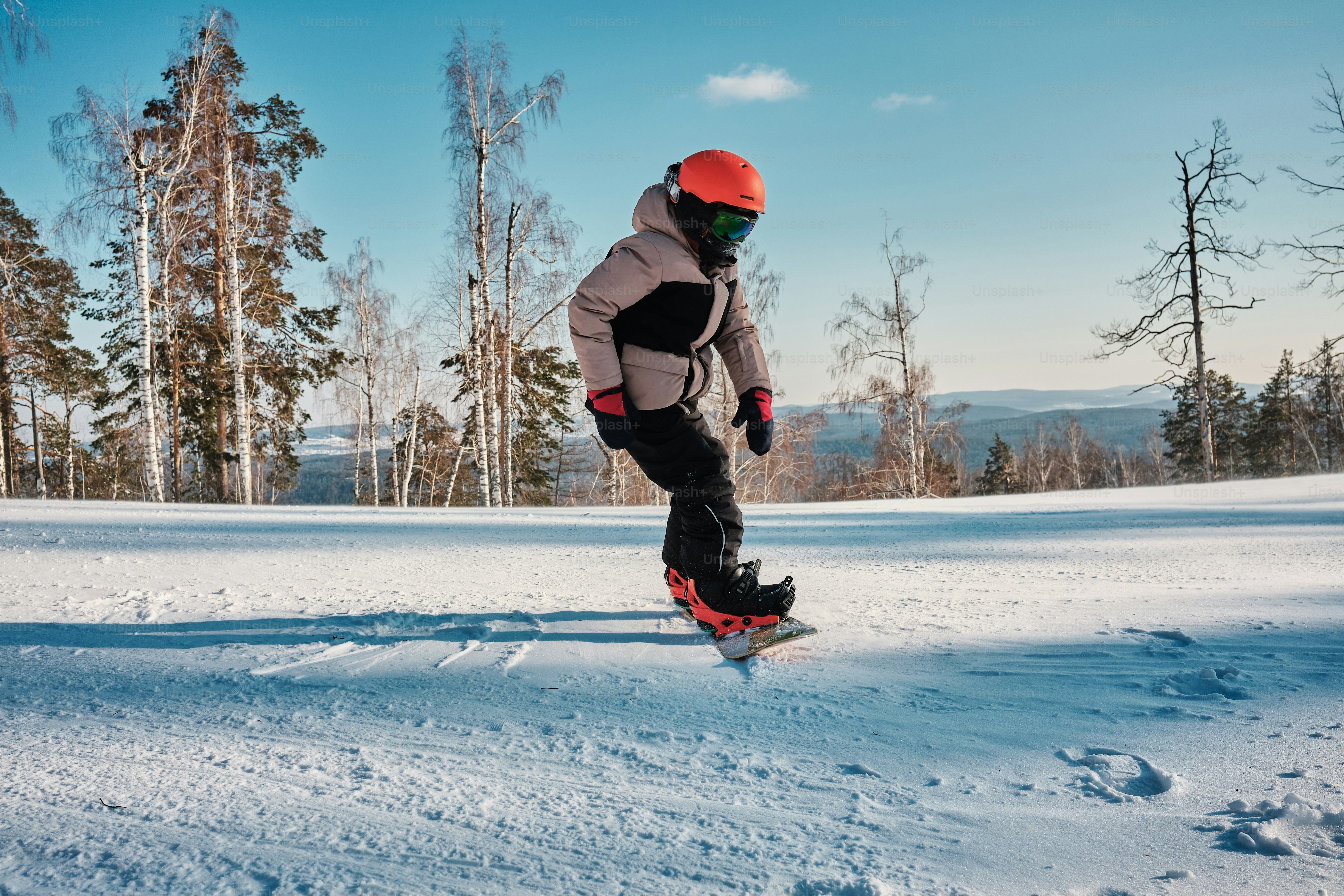 un uomo che cavalca uno snowboard lungo un pendio innevato