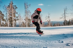 a man riding a snowboard down a snow covered slope