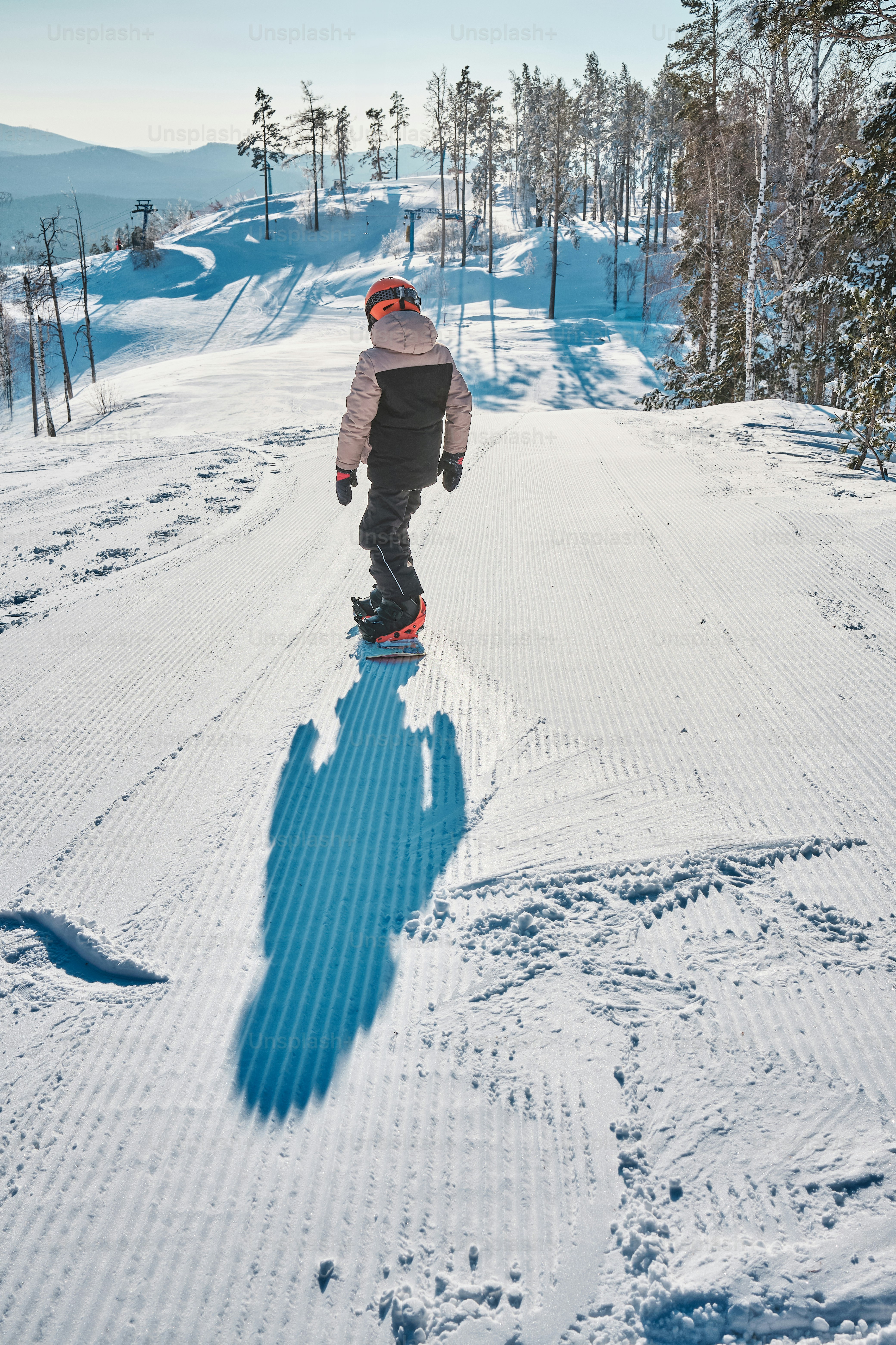 a man riding a snowboard down a snow covered slope
