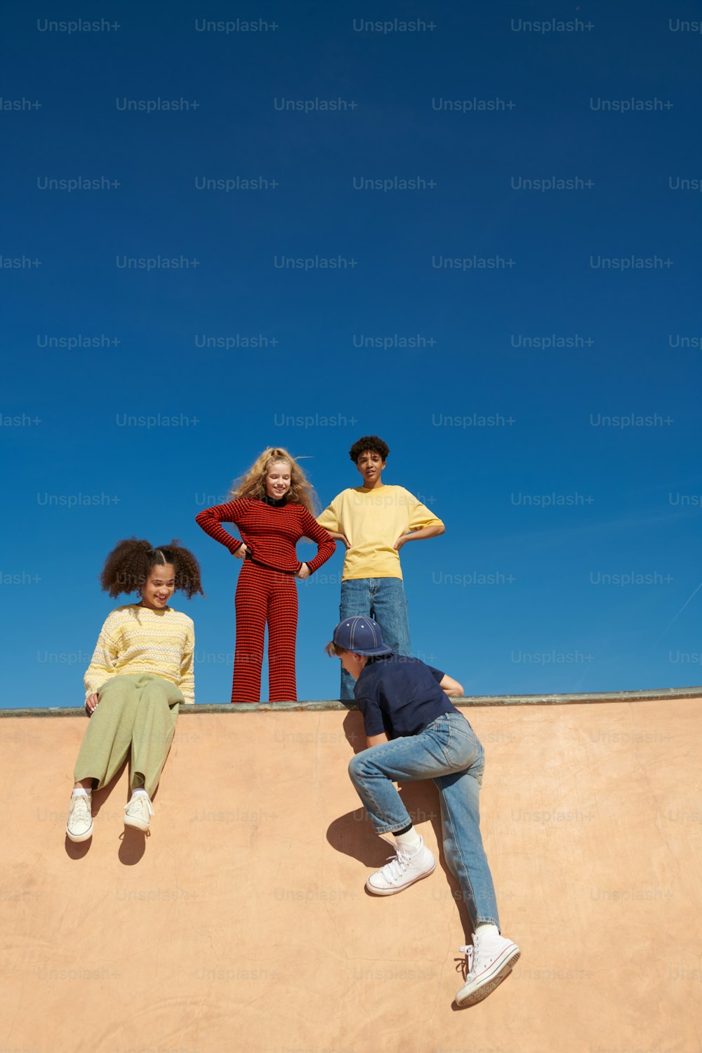 a group of people sitting on top of a skateboard ramp