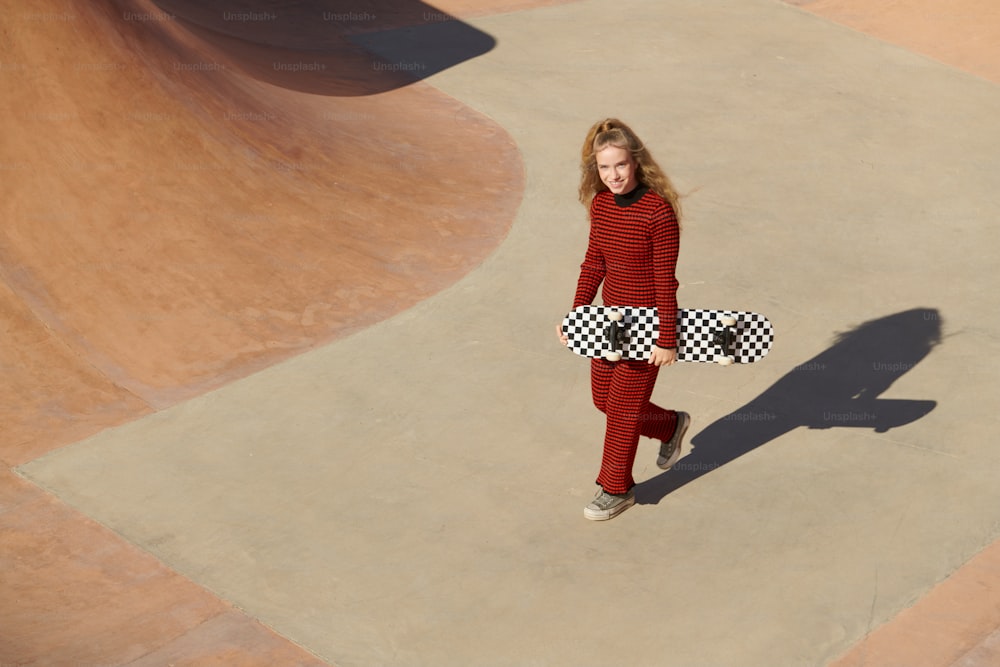a woman in a red sweater holding a skateboard