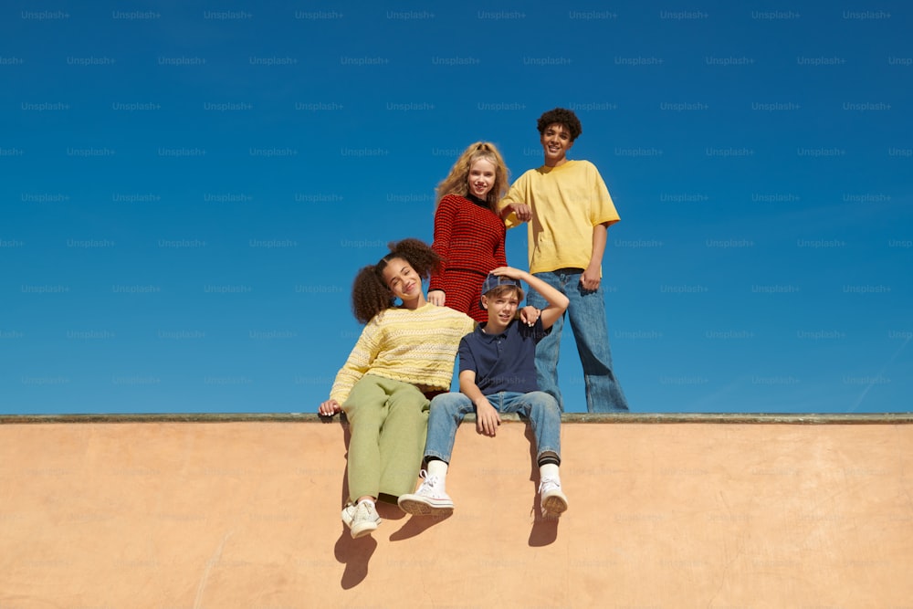 a group of people sitting on top of a skateboard ramp