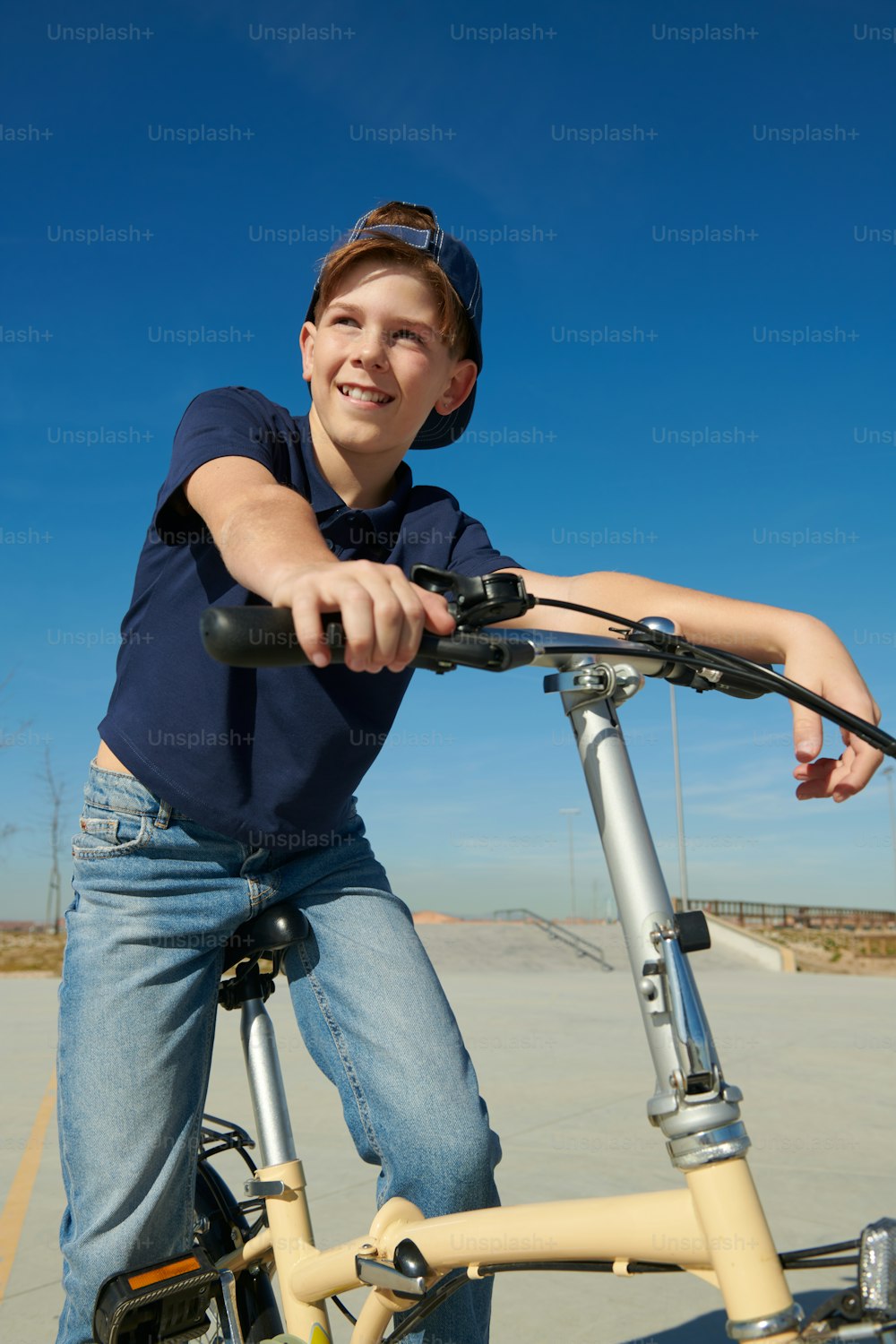 a young boy sitting on a bike in a parking lot