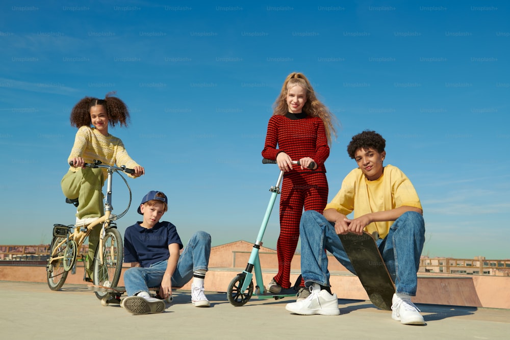 a group of young people sitting on top of a skateboard