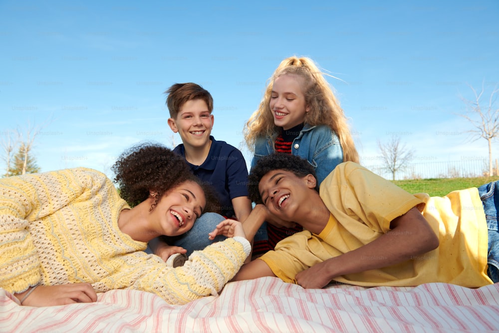 a group of young people laying on top of a bed