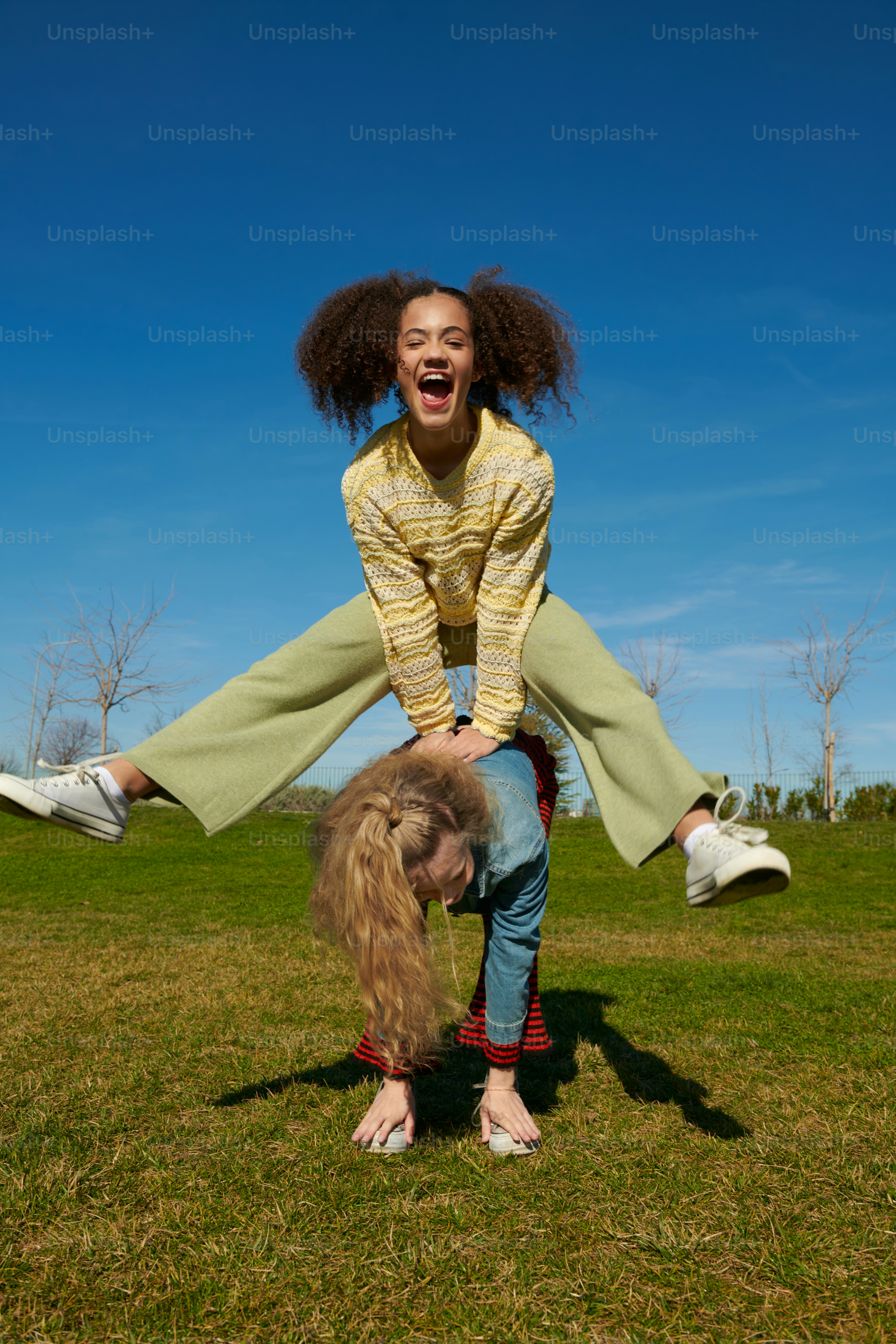 Una donna sta facendo una verticale sulla testa di un'altra donna