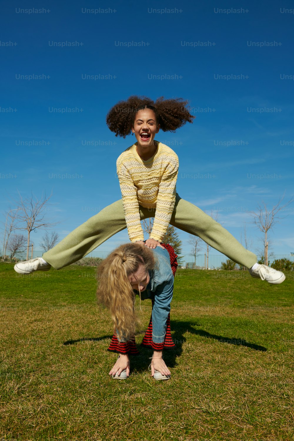 a woman doing a handstand on top of another woman