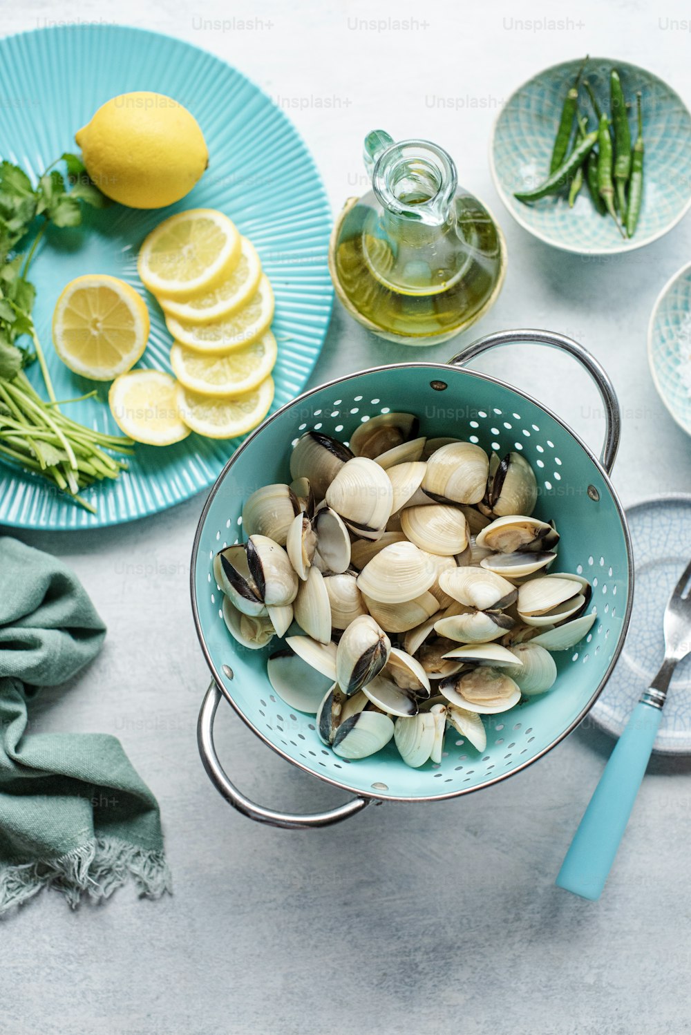 a blue colander filled with clams and lemon slices