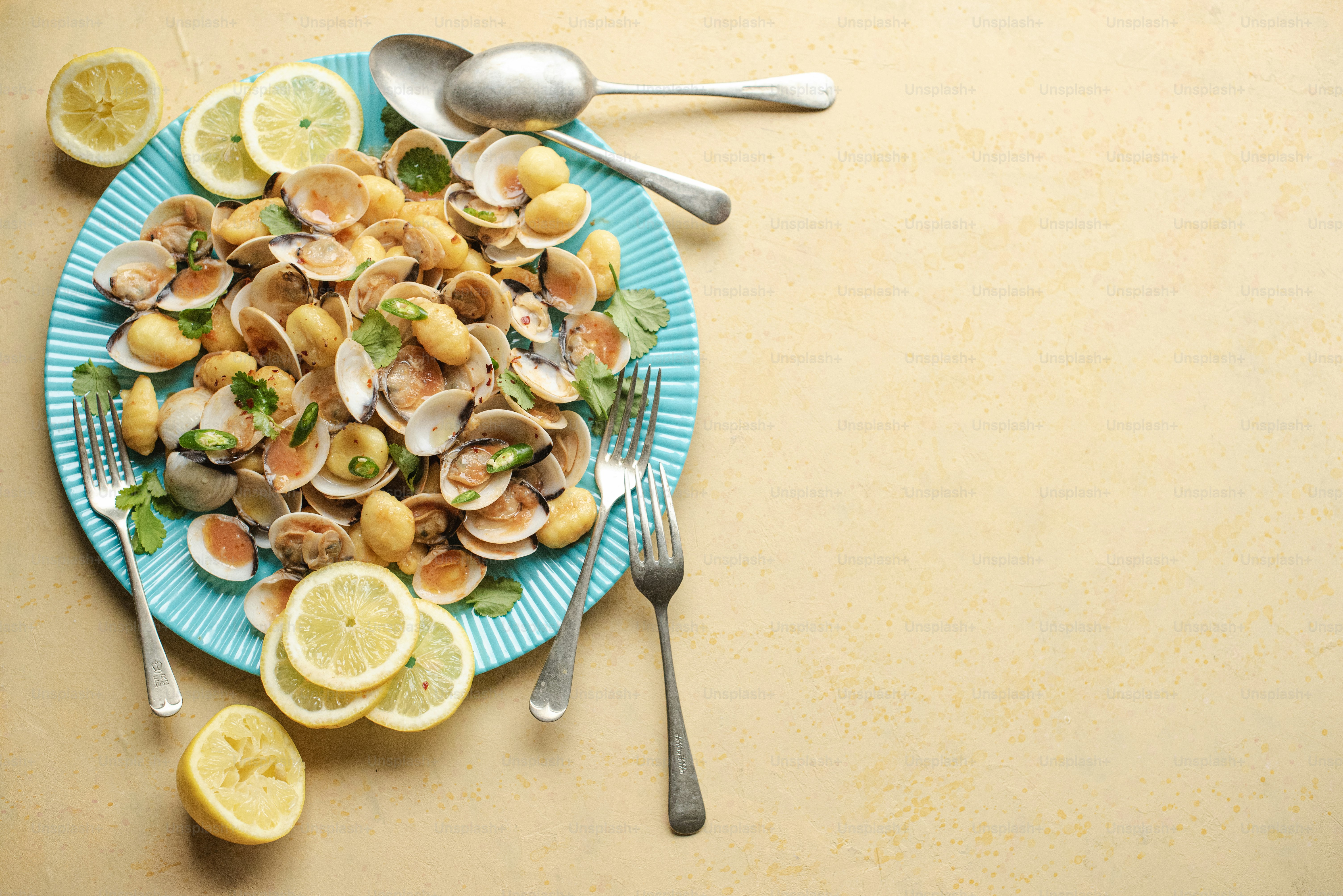 a blue plate topped with clams and lemon slices