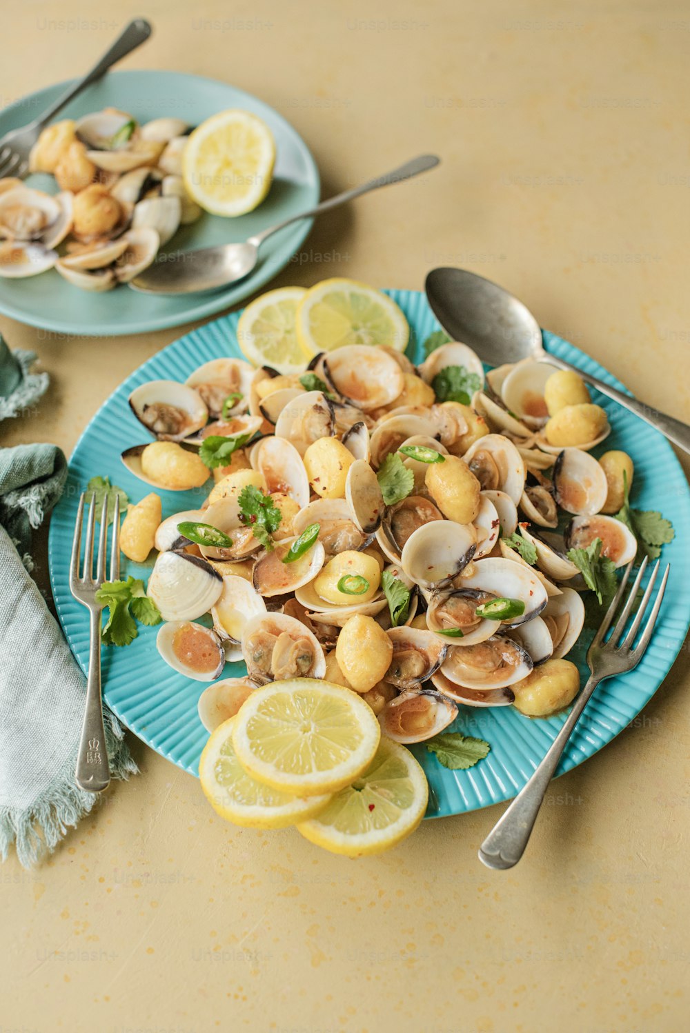 a blue plate topped with clams and lemon slices