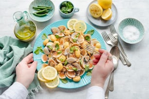 a plate of clams with lemons and greens