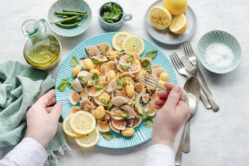 a plate of clams with lemons and greens