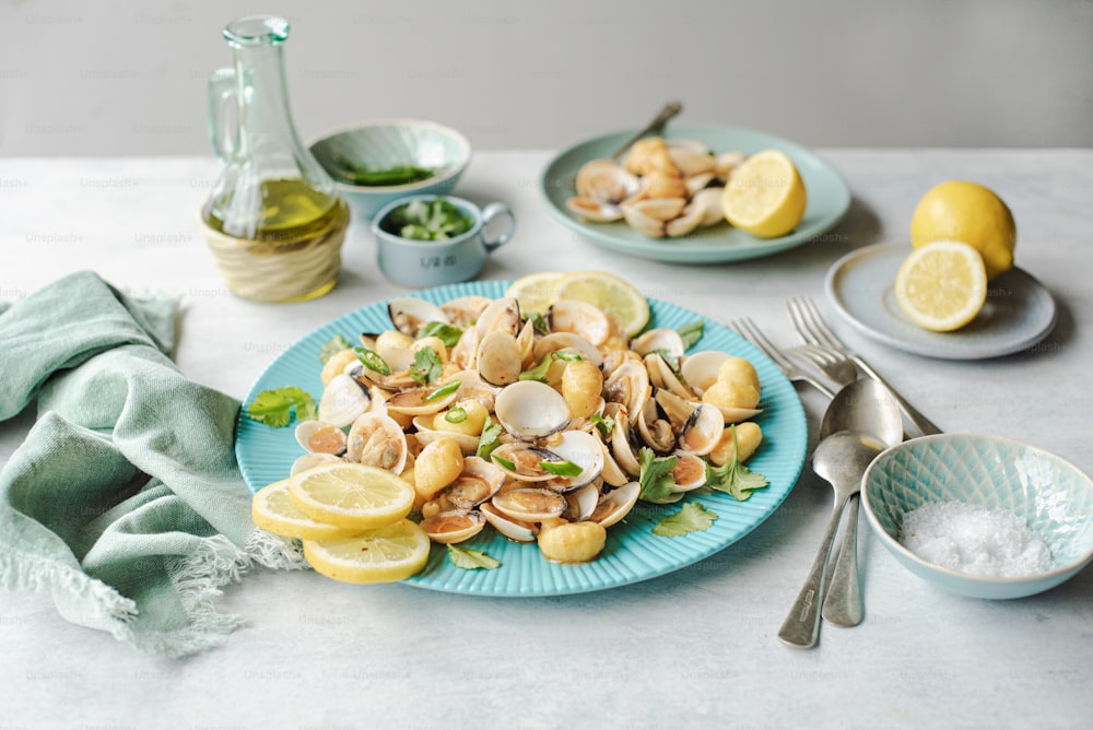 a plate of pasta with clams and lemons