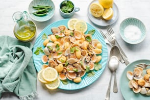 a blue plate topped with clams and lemon slices