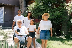 eine Gruppe von Menschen, die um eine Frau im Rollstuhl herum stehen