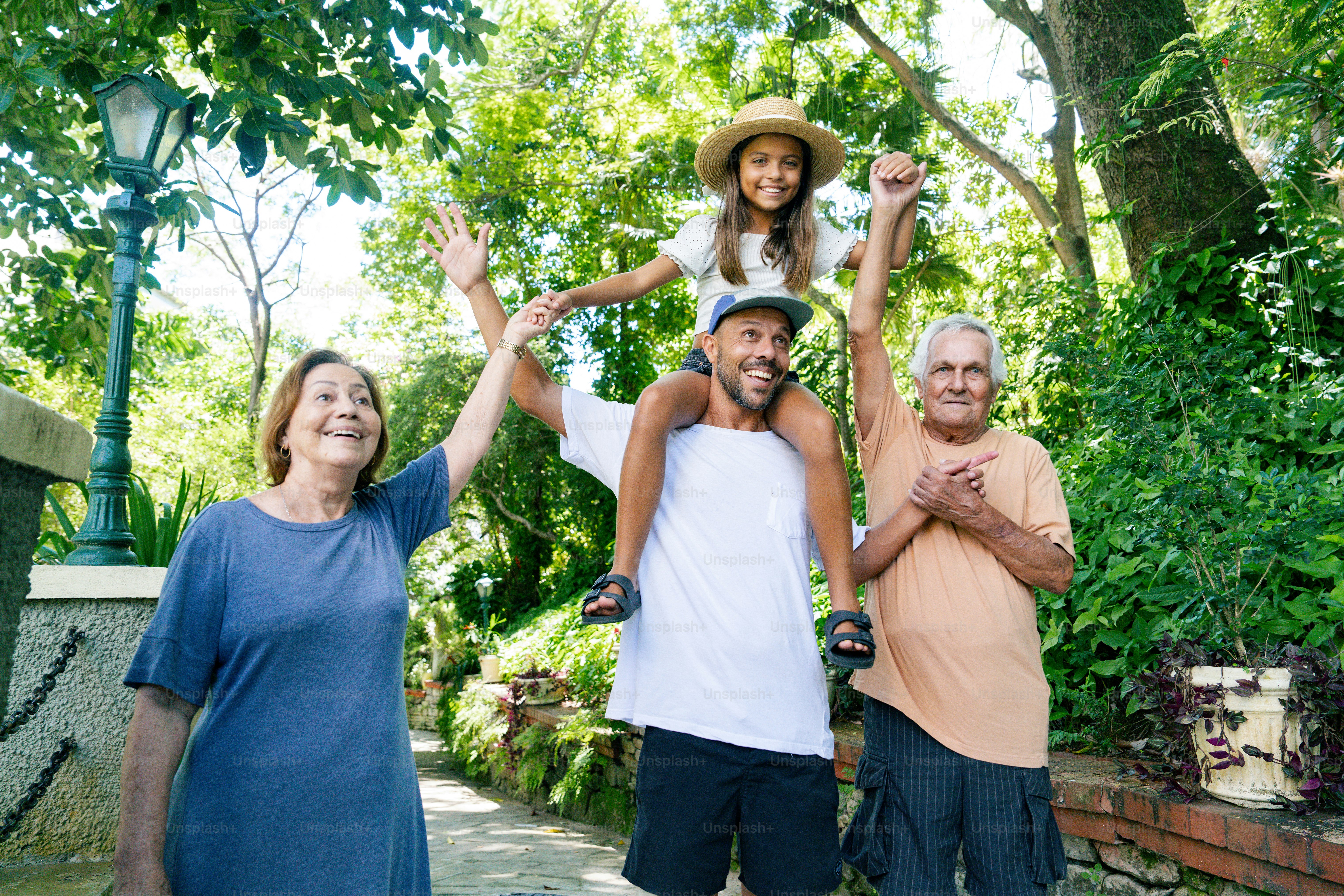 a man and two women are holding a child on their shoulders