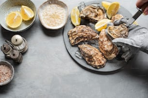 a plate of oysters on a table with lemons