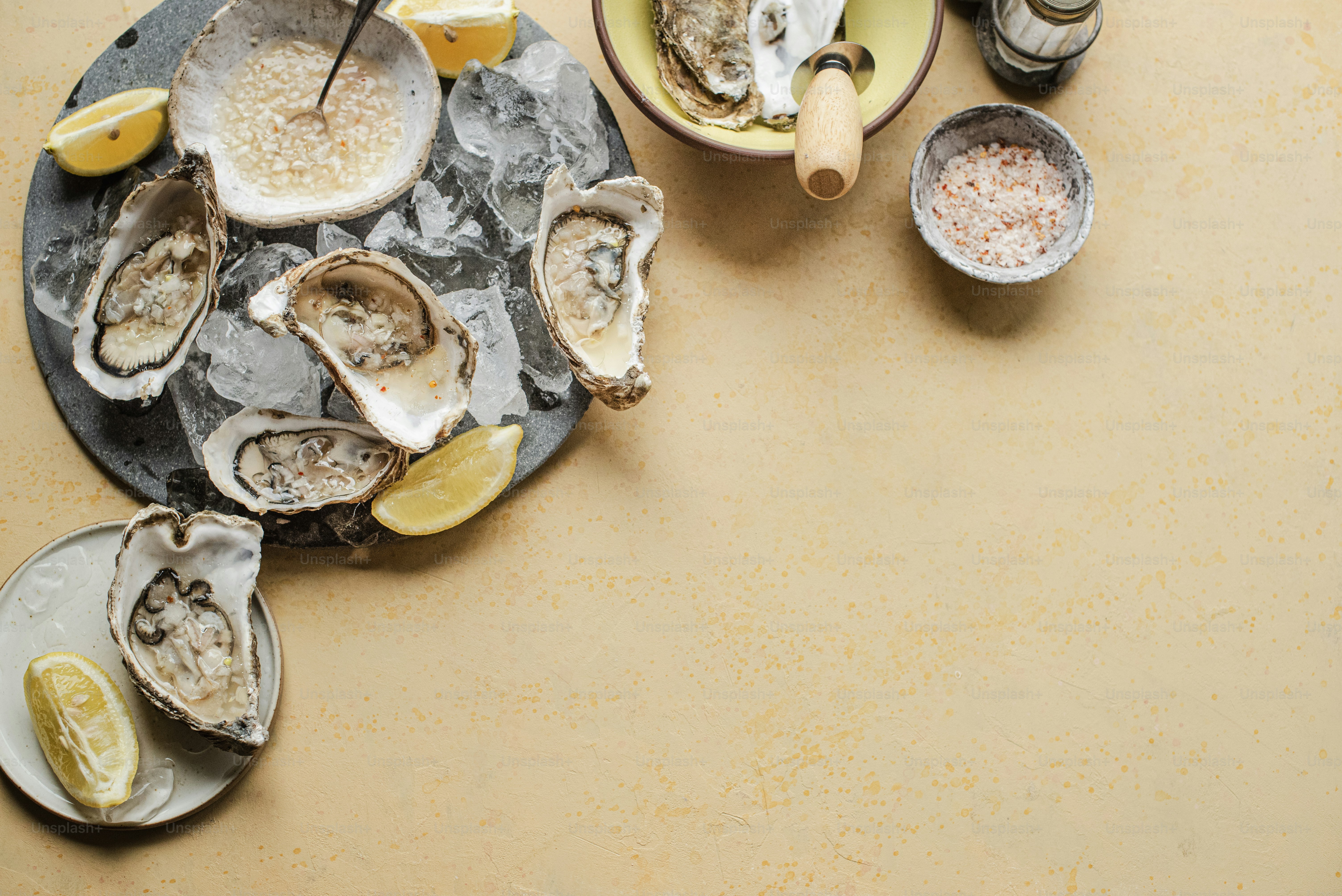 a table topped with oysters and lemon wedges
