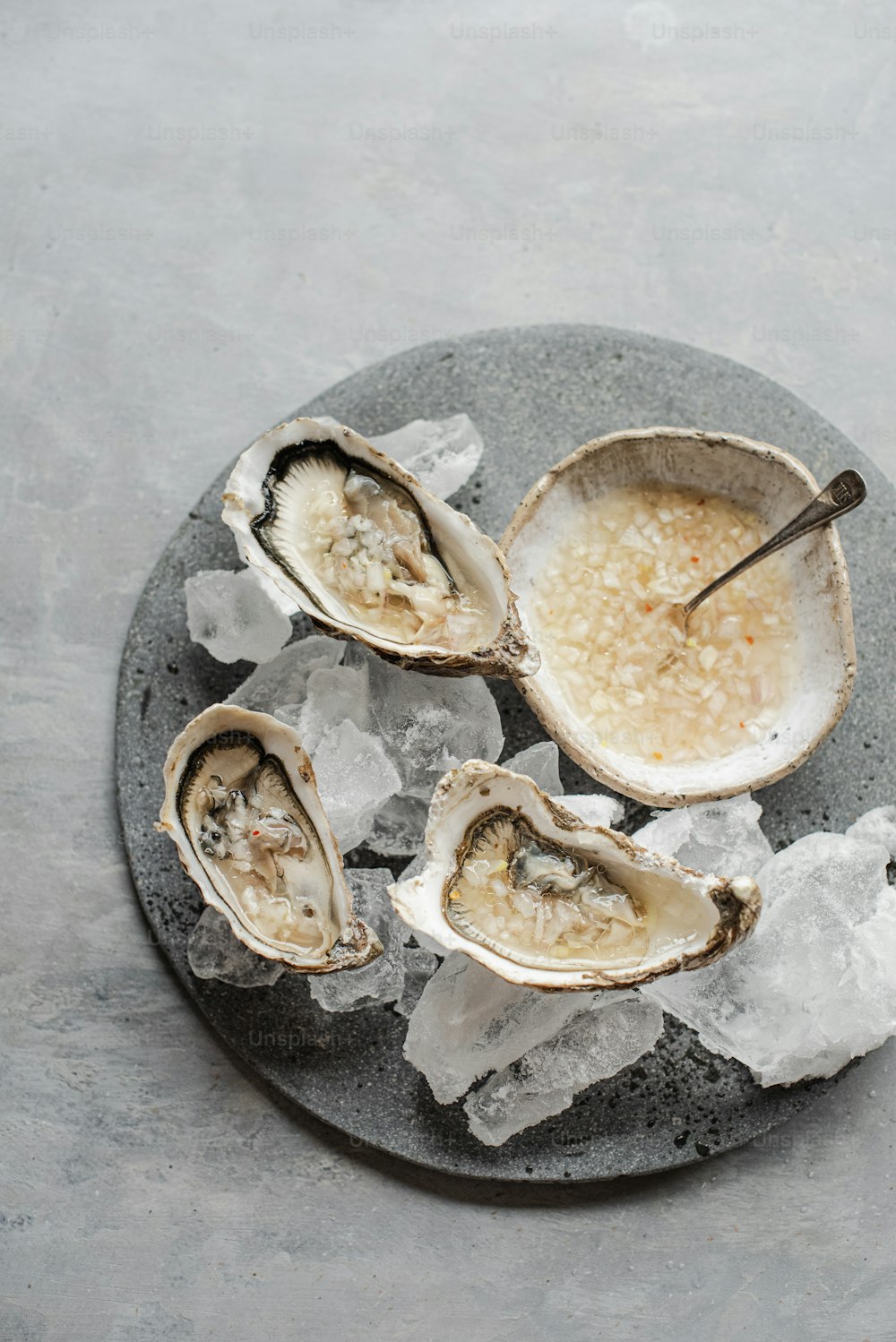 a plate of oysters on ice with a spoon
