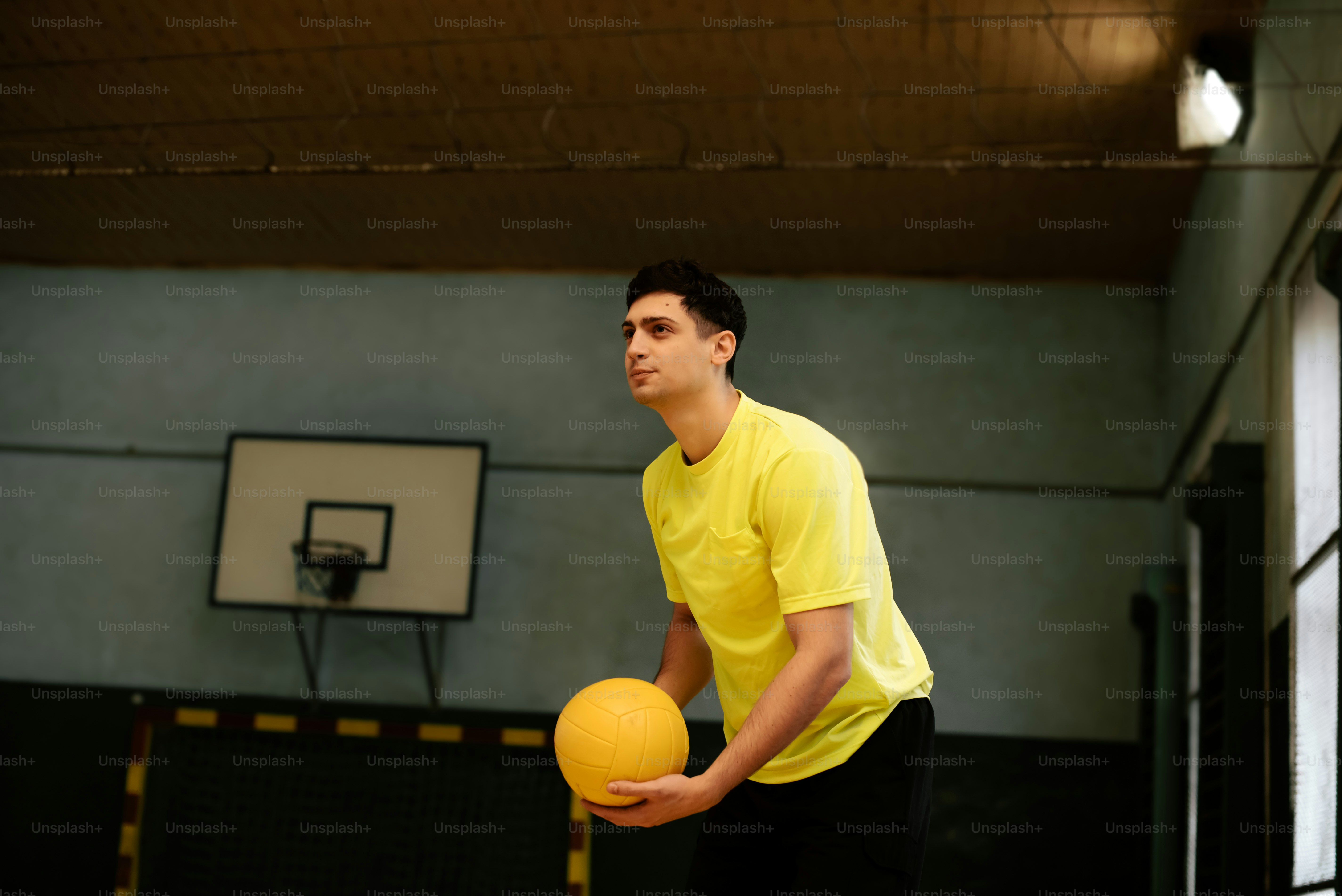 a man in a yellow shirt holding a yellow ball