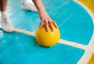 a person is holding a yellow ball on a court