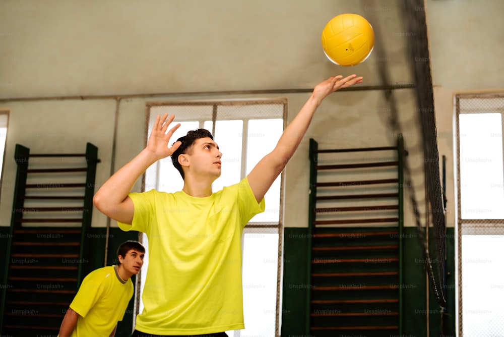 黄色いシャツを着た男性が黄色いボールで遊んでいます