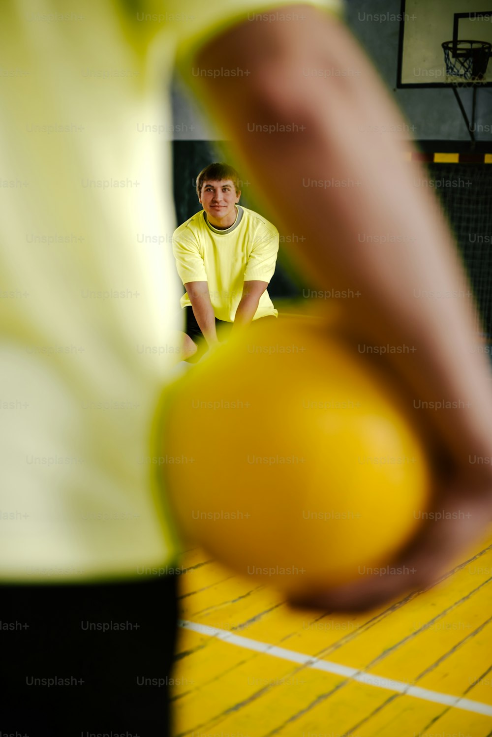 a man in a yellow shirt holding a yellow ball