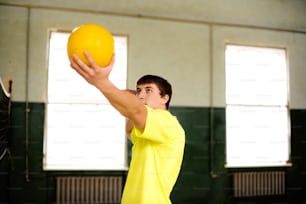 a man in a yellow shirt is holding a yellow frisbee