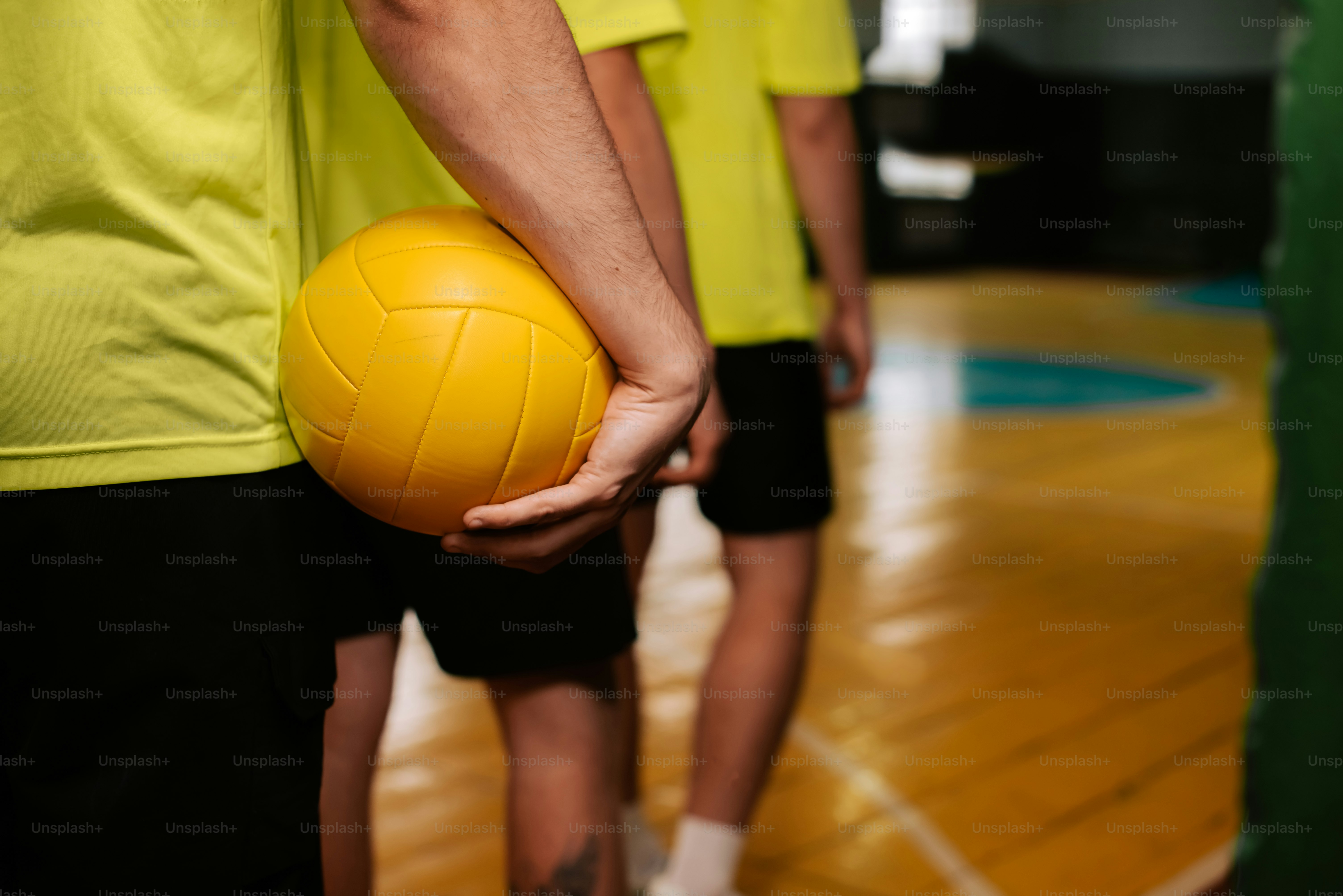 eine Person, die einen gelben Ball in der Hand hält